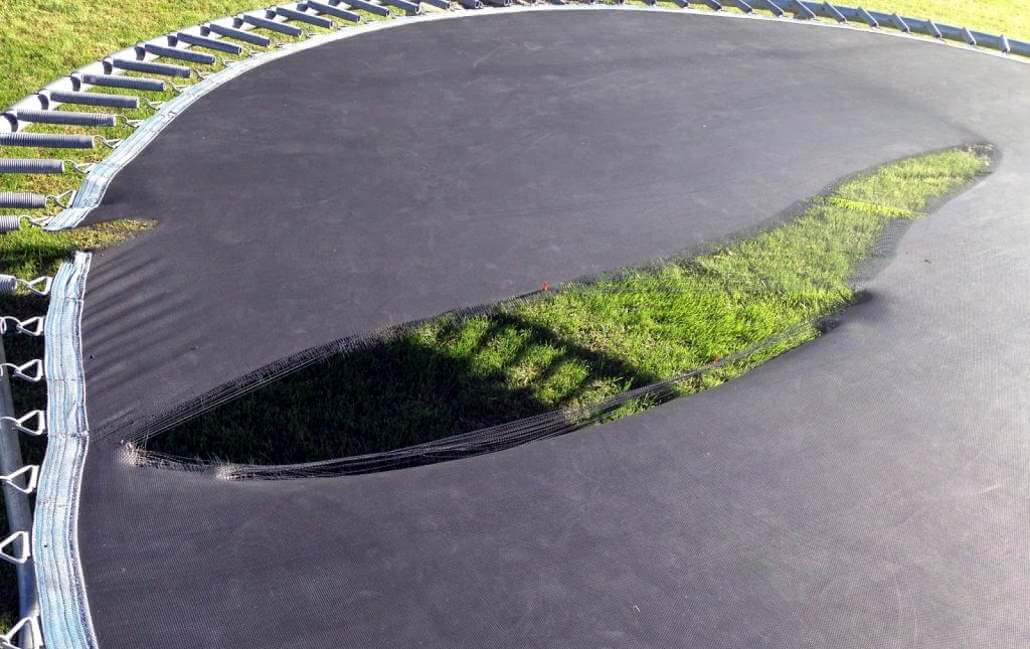 Inspecting the mat to stay safe - image of ripped mat